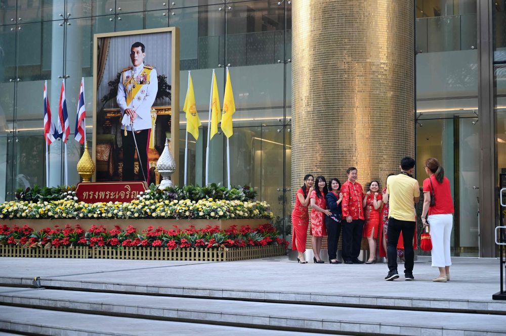 A group of people wearing colourful outfits pose for picture next to a large portrait of Thai King Maha Vajiralongkorn in Bangkok February 5, 2019 during the Lunar New Year. u00e2u20acu201d AFP pic