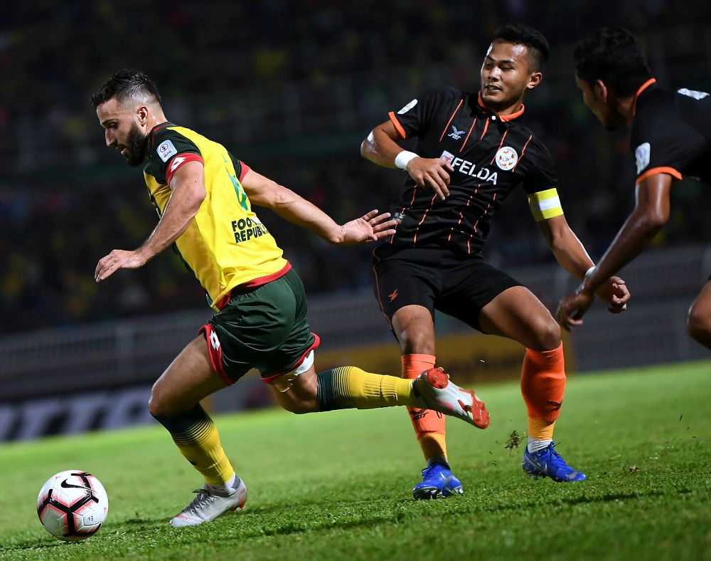 Kedahu00e2u20acu2122s Anmar Fares Abdul Jabar Almubaraki in action with Felda United FCu00e2u20acu2122s Ahmad Haziq Ahmad Fuad (right) dan Mohammad Raffi Nagoorgani (second right) during the Super League match at Stadium Darul Aman yesterday. u00e2u20acu201d Bernama pic