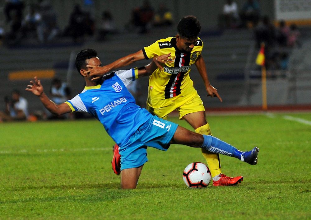 Penangu00e2u20acu2122s Dhiyaulrahman Mohd Hasry (left) is tackled by PDRM FAu00e2u20acu2122s Amir Saiful Badeli during their Premier League match at Stadium Bandaraya yesterday. u00e2u20acu201d Bernama pic