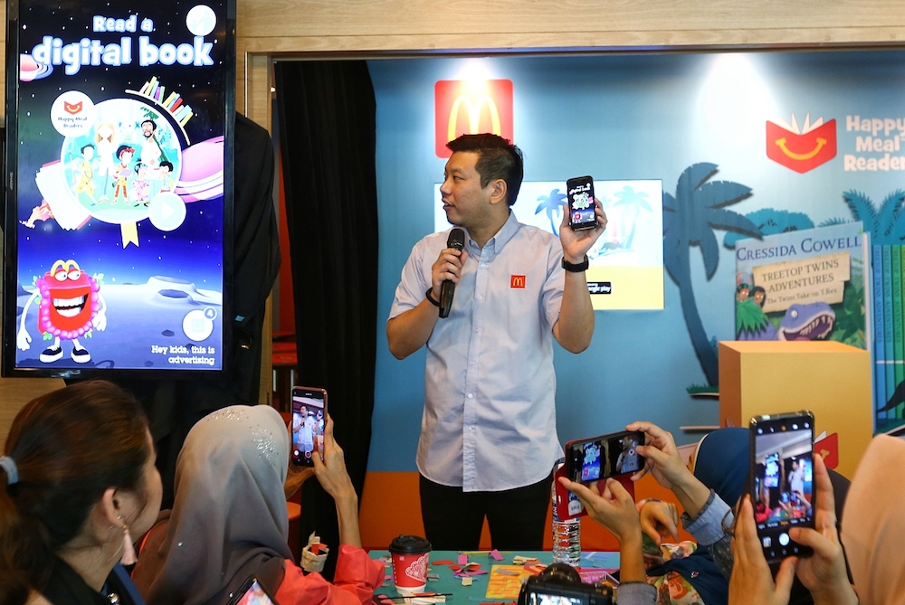 McDonald’s marketing director Eugene Lee demonstrates the features of the Happy Studio mobile application. — Picture by Ahmad Zamzahuri
