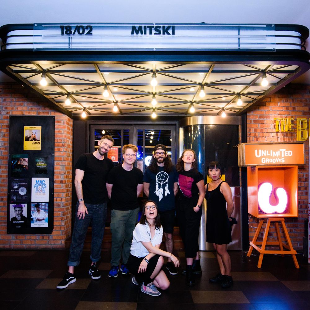 Mitski and her bandmates pose outside The Bee, Publika.