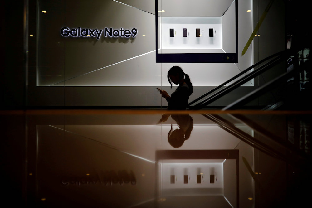A woman using her mobile phone rides on an escalator at Samsung Electronicsu00e2u20acu2122 office building in Seoul January 7, 2019. u00e2u20acu201d Reuters pic