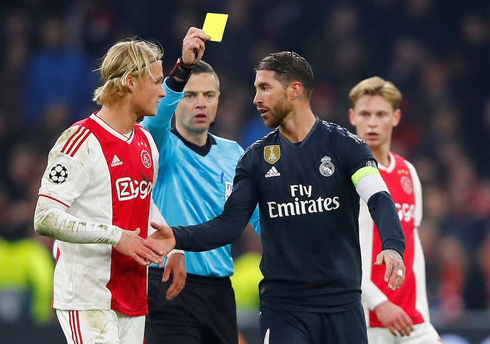 Real Madridu00e2u20acu2122s Sergio Ramos is shown a yellow card by referee Damir Skomina as Ajaxu00e2u20acu2122s Kasper Dolberg looks on during their Champions League Round of 16 first leg match at Johan Cruijff Arena in Amsterdam February 13, 2019. u00e2u20acu201d Reuters pic