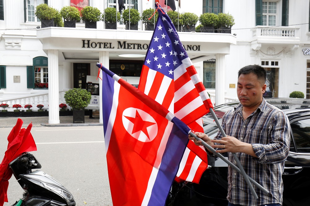 A man places North Korean and US flags in the street ahead of the summit in Hanoi February 19, 2019. u00e2u20acu201d Reuters pic