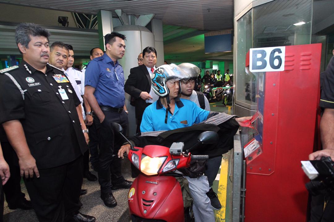 Deputy Home Minister Datuk Azis Jamman (second left) watches a motorcycle rider using his RFID card at the CIQ Complex at the Sultan Iskandar Building in Johor Baru February 11, 2019.u00e2u20acu201d Picture courtesy of the Johor Immigration Department