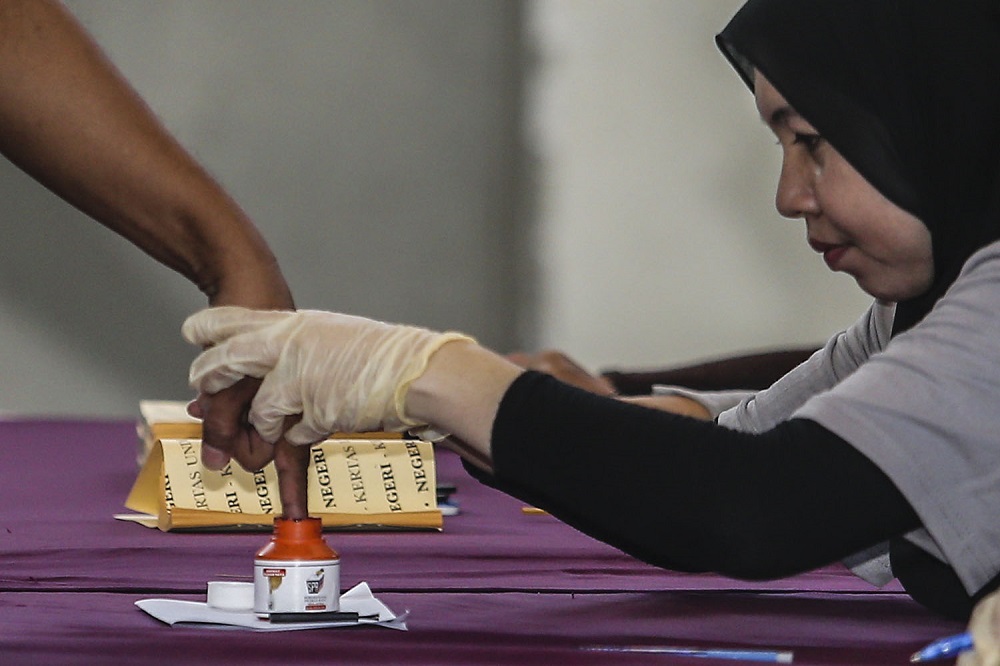 An Election Commission officer dips a voteru00e2u20acu2122s finger in indelible ink at the Battalion 4 General Operations Force Camp in Semenyih February 26, 2019. u00e2u20acu201d Picture by Hari Anggara
