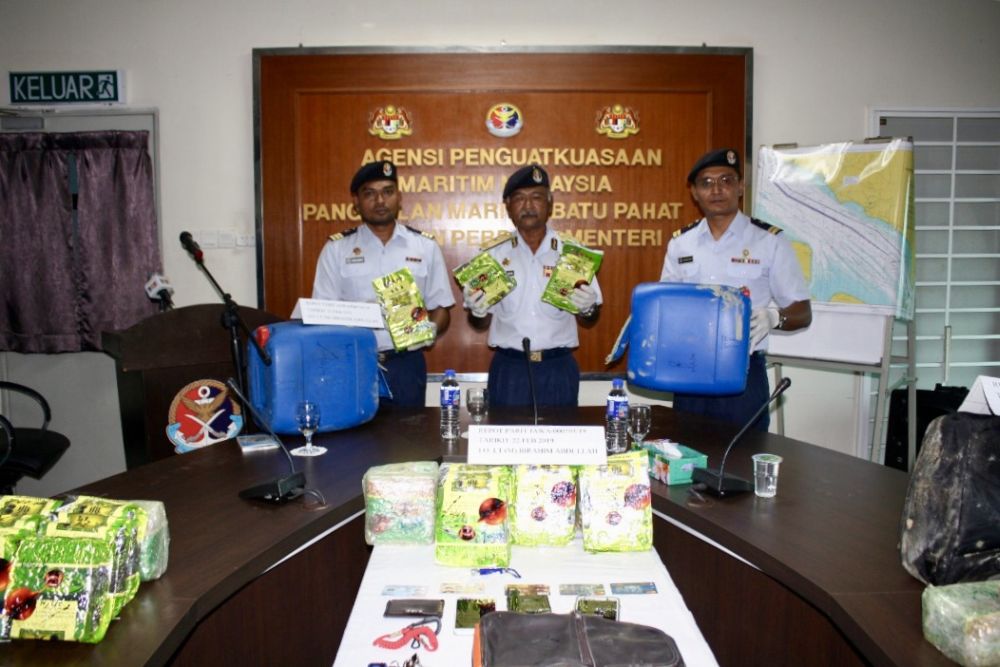 Johor MMEA director First Admiral Aminuddin Abdul Rashid (centre) holds up the Chinese tea packets that contain syabu that was seized yesterday. u00e2u20acu201d Picture courtesy of the Malaysian Maritime Enforcement Agency