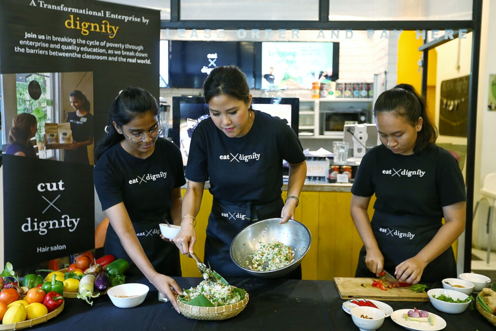 Azis Fatima (left) assists Diana Chan (centre) with preparations along with another student known as Sharina. — Picture by Ahmad Zamzahuri