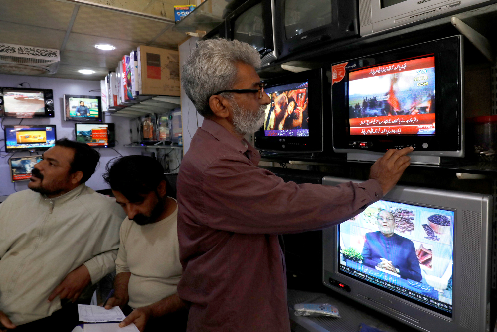 A man looks at television screens, after Pakistan shot down two Indian planes, at a shop in Karachi February 27, 2019. u00e2u20acu201d Reuters pic