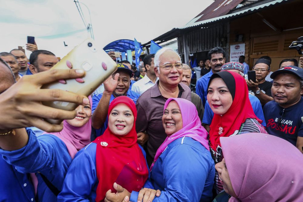 Datuk Seri Najib Razak (centre) poses for a selfie with BN supporters during a walkabout at the Pasar Tani Beranang in Semenyih February 20, 2019. 
