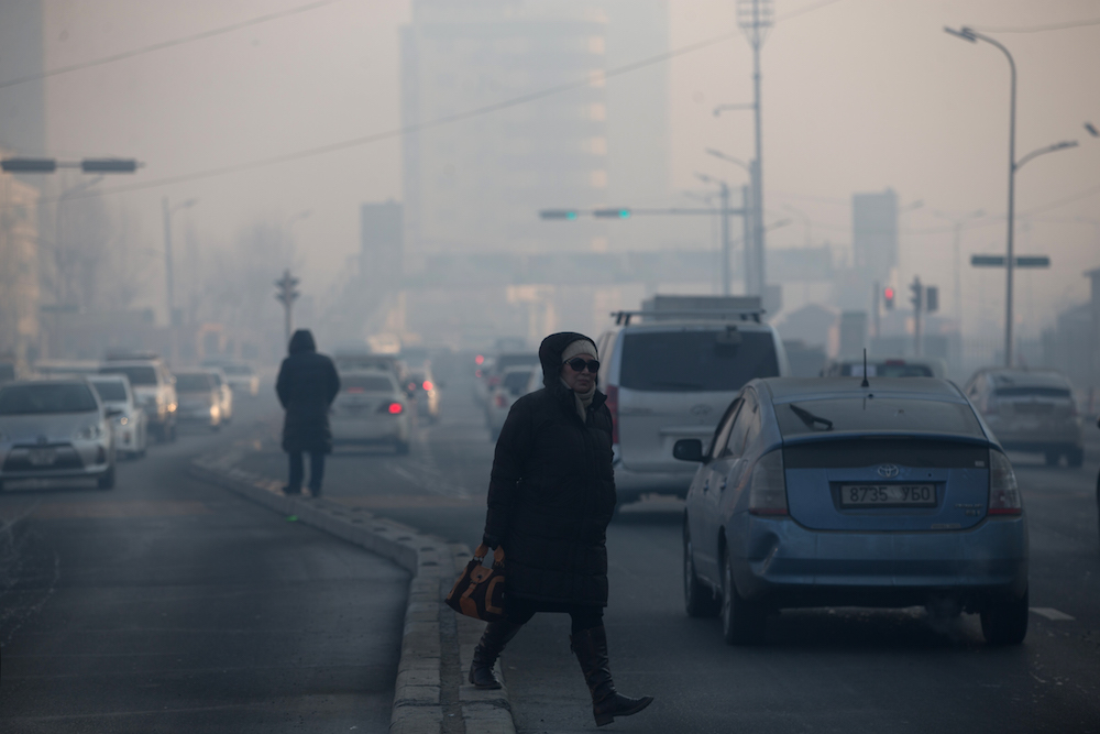 A woman walks across a road on a polluted day in Ulaanbaatar, the capital of Mongolia, February 14, 2019. u00e2u20acu201d AFP pic