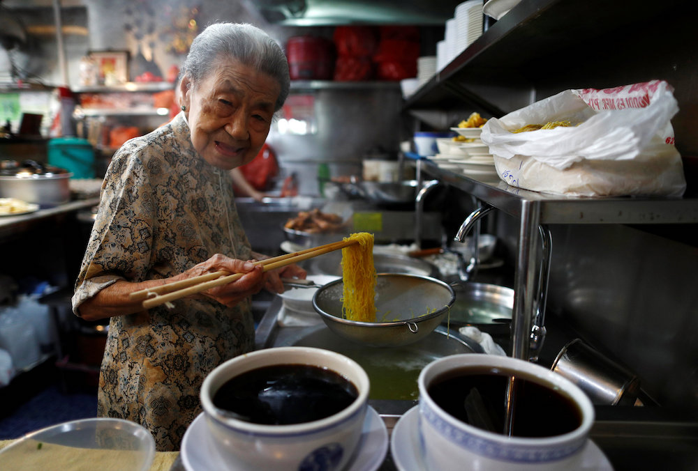 Hawker Leong Yuet Meng, of Nam Seng Noodle House, poses as she cooks noodles at her shop in Singapore February 22, 2019. u00e2u20acu201d Reuters pic