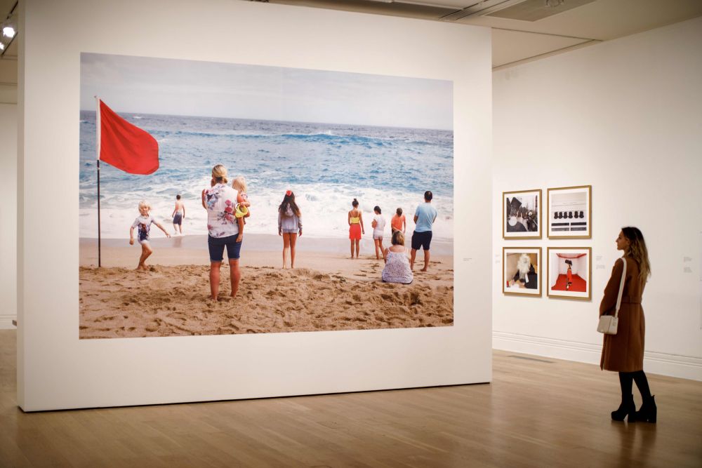 A visitor looks at photographs displayed at the Only Human: Photographs by Martin Parr exhibition during the press preview at National Portrait Gallery in London March 6, 2019. — Tolga Akmen pic via AFP