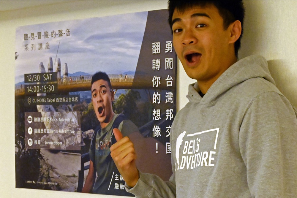 This picture taken on February 13, 2019 shows Taiwanese YouTuber Ben Wu gesturing in front of a poster of himself during his travels during an interview in Taipei. u00e2u20acu201d AFP pic
