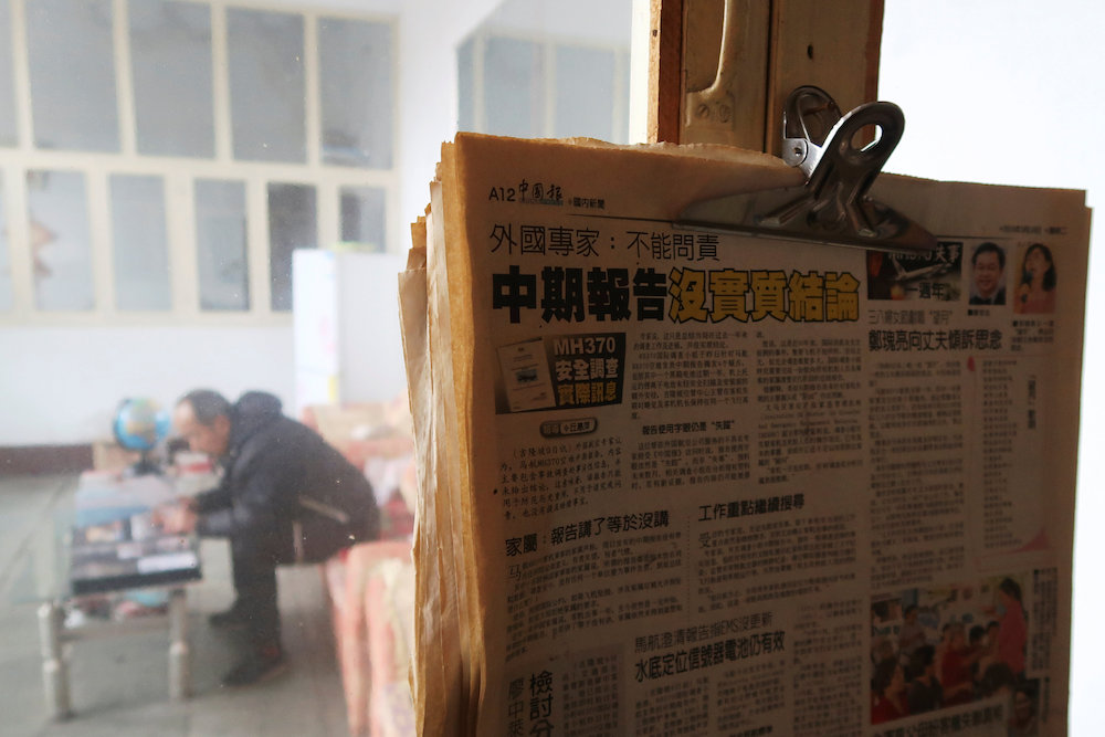 Newspapers with articles on the missing Malaysia Airlines flight MH370 hang by a window as Li Eryou looks at a photo album during a Reuters interview at his house in Handan, Hebei province, China March 1, 2019. — Reuters pic