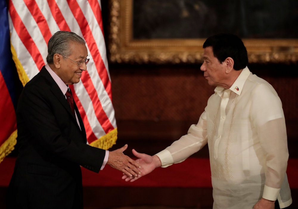Tun Dr Mahathir Mohamad and Philippine President Rodrigo Duterte greet each other before a joint press conference at the Malacanang Presidential palace in Manila March 7, 2019. u00e2u20acu201d Reuters pic