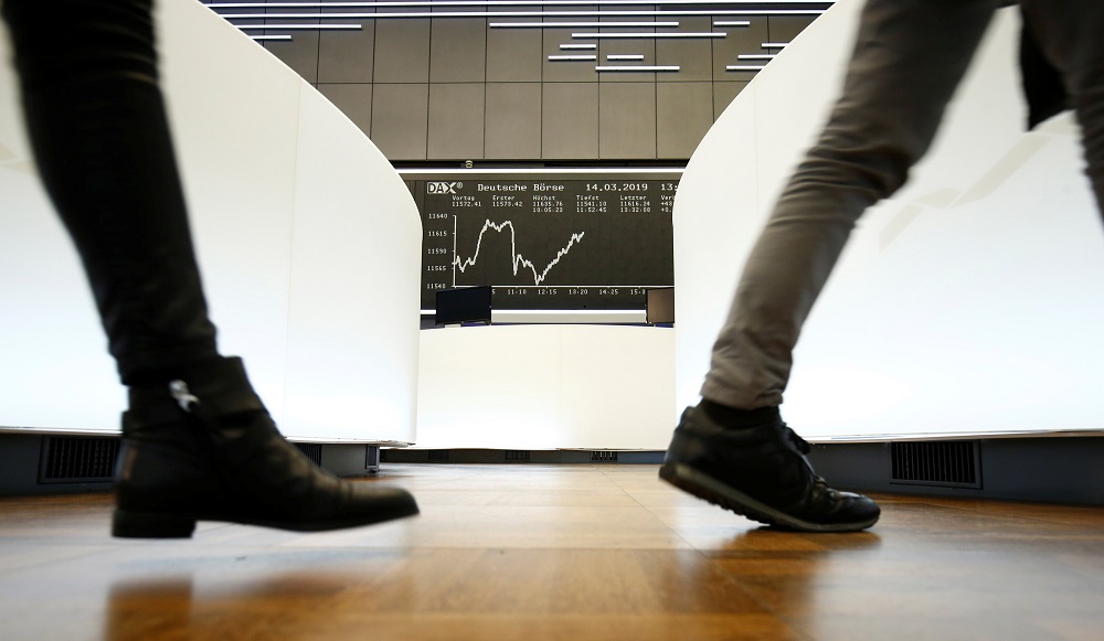 Traders walk past the German share price index DAX graph at Frankfurtu00e2u20acu2122s stock exchange in Frankfurt  March 14, 2019. u00e2u20acu201d Reuters pic