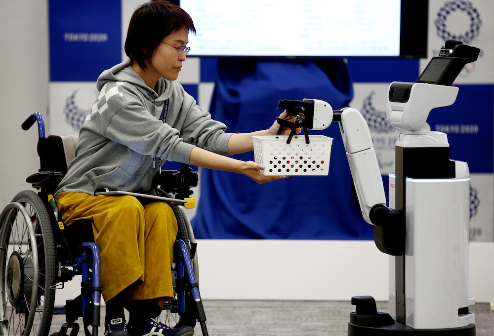 Toyotau00e2u20acu2122s Human Support Robot (HSR) delivers a basket to a woman in a wheelchair at a demonstration of Tokyo 2020 Robot Project for Tokyo 2020 Olympic Games in Tokyo March 15, 2019. u00e2u20acu201d Reuters pic