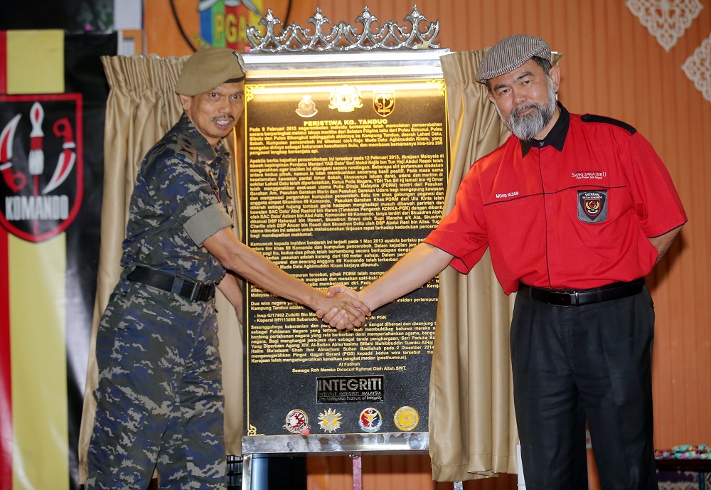 Institute of Integrity Malaysia senior-director Mohd Nizam Mohd Ali (right) presents the memorial plaque to VAT 69 commander senior assistant commissioner Abdul Razak Mohd Yusoff.