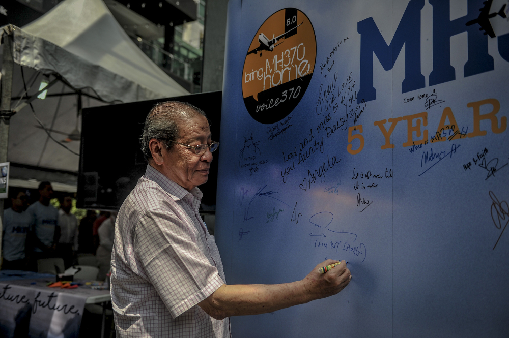 DAP’s Lim Kit Siang writes a condolence message during the remembrance ceremony to mark the 5th anniversary of MH370’s disappearance in Kuala Lumpur March 3, 2019. — Picture by FIrdaus Latif 