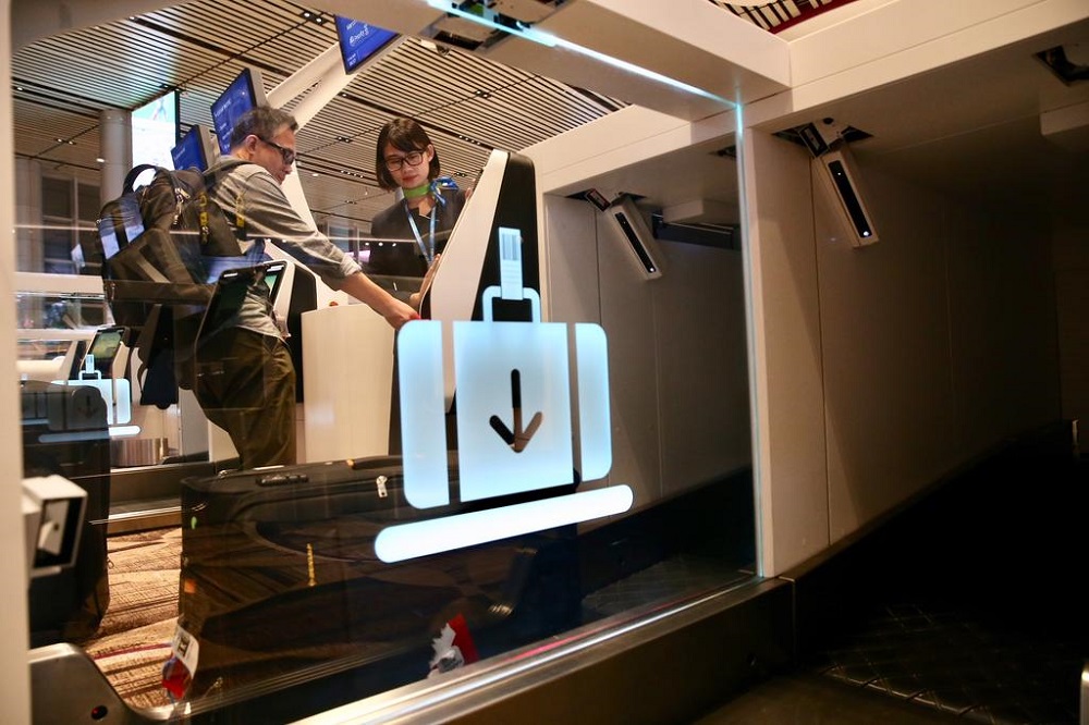 A passenger checking in his luggage at Changi Airport Terminal 4. u00e2u20acu201d TODAY pic