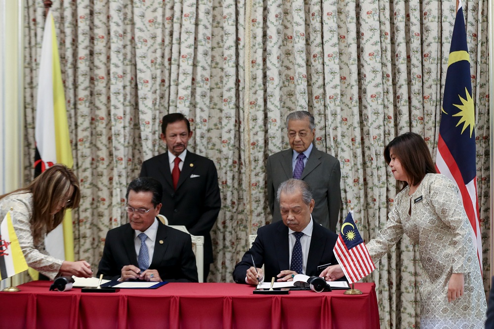 Home Minister Tan Sri Muhyiddin Yassin (seated, right) and Brunei home affairs minister Datuk Seri Awang Abu Bakar Apong (seated, left) at the signing of the MoU in Putrajaya March 5,2019. u00e2u20acu201d Picture by Ahmad Zamzahuri