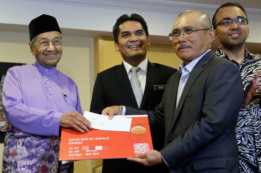 Datuk Seri Dr Ronald Kiandee received his Bersatu membership card from chairman Tun Dr Mahathir Mohamad during the Bersatu membership card handing-over ceremony in Putrajaya March 15, 2019. u00e2u20acu201d Picture by Yusof Mat Isa