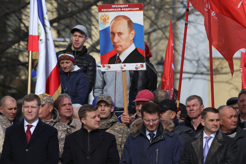 A man holds a board with a portrait of Russian President Vladimir Putin during celebrations of the fifth anniversary of Russia's annexation of Crimea in Simferopol, Crimea March 15, 2019. u00e2u20acu201d Reuters pic