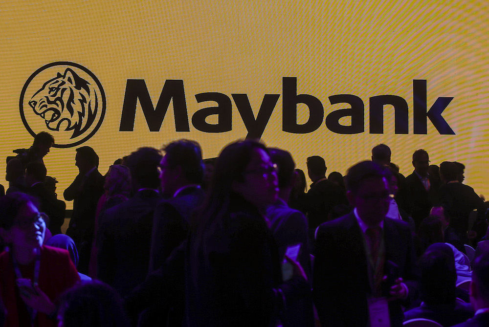 The silhouettes of attendees are seen in front of a screen with the Maybank logo at Invest Malaysia 2019 in Kuala Lumpur March 19, 2019. u00e2u20acu201d Picture by Firdaus Latif
