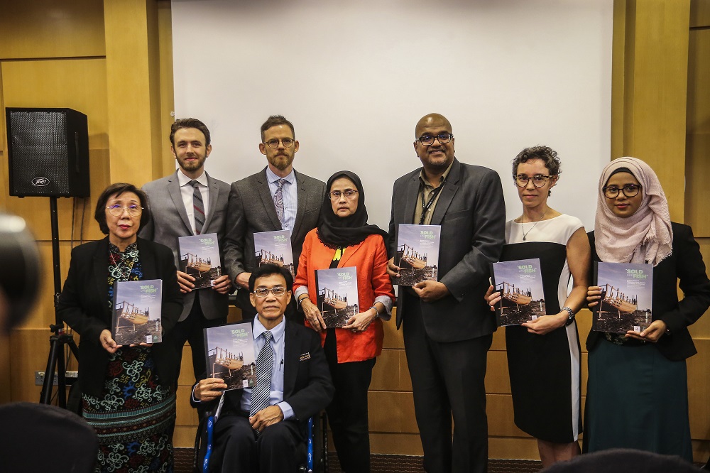 Suhakam commissioner Francis johen Anak Adam (seated in wheelchair) with other members of the panel pose for a group photo during the launch of Suhakamu00e2u20acu2122s report titled u00e2u20acu02dcSold Like Fishu00e2u20acu2122 in Kuala Lumpur March 27, 2019. u00e2u20acu201d Picture by Firdaus Latif 