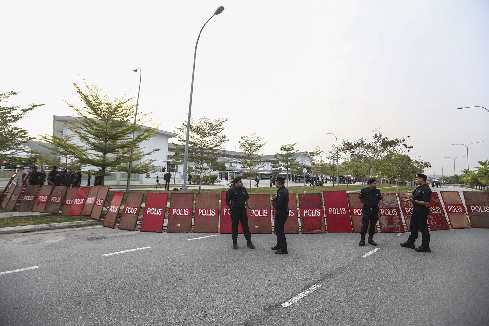 Members of the police force stand guard outside the nomination centre for the Rantau by-election at Sekolah Kebangsaan u00c2u00a9 Bandar Sri Sendayan in Seremban March 30, 2019. u00e2u20acu201d Picture by Yusof Mat Isa