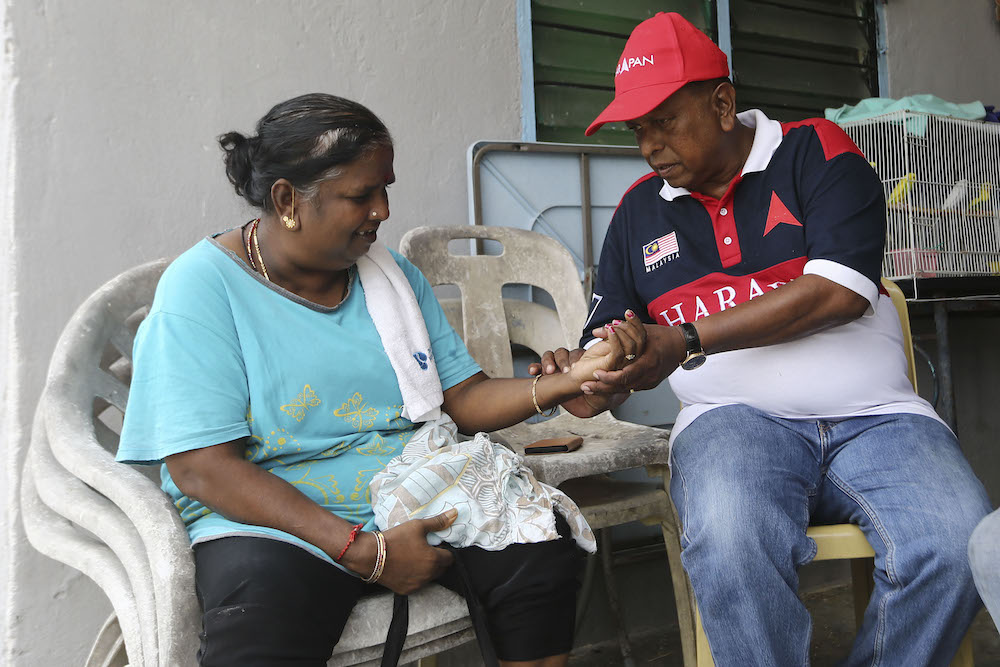 Pakatan Harapan candidate, Dr S. Streram checks the pulse of a Taman Bunga Raya Kuala Sawah resident while on his campaign in Rantau March 31, 2019. u00e2u20acu201d Picture by Yusof Mat Isa