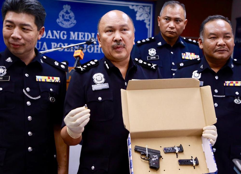 Johor deputy police chief Datuk Mohd Kamarudin Md Din with the seized Browning pistol during a press conference at the Johor police contingent headquarters today. u00e2u20acu201d Picture by Roysten Rueben