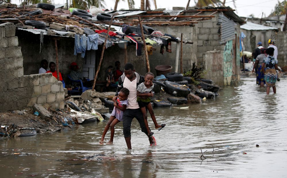 A man carries his children after Cyclone Idai at Praia Nova, in Beira, Mozambique, March 23, 2019. u00e2u20acu201d Reuters pic