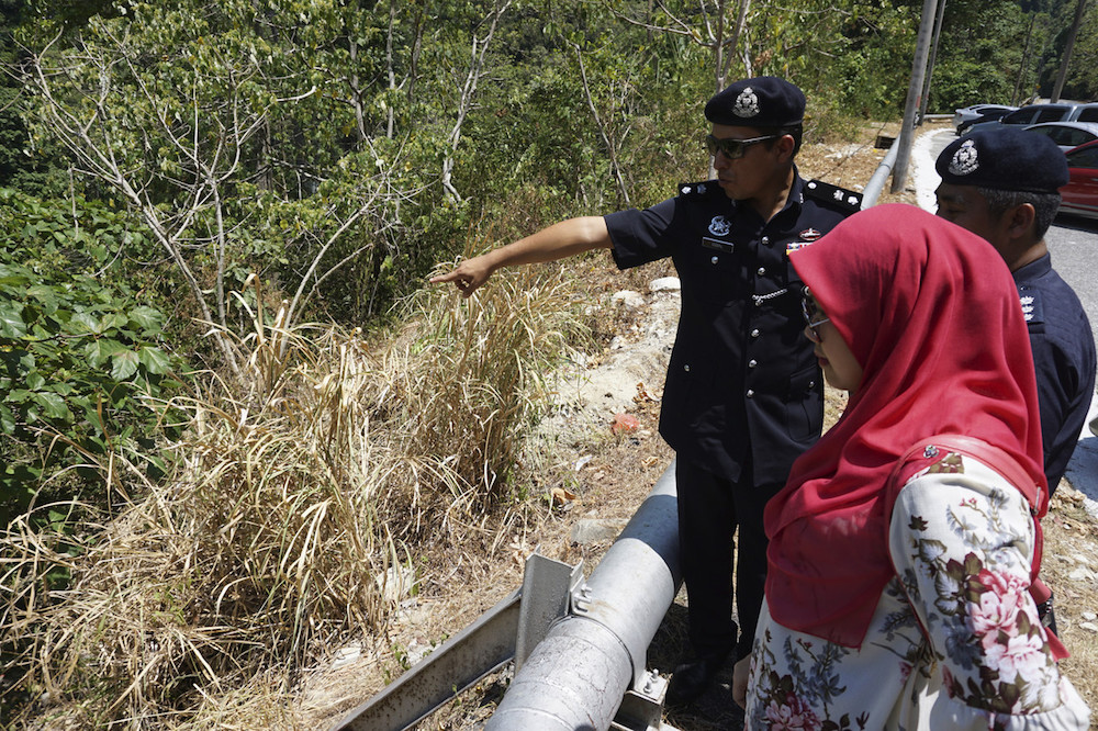 Langkawi district police chief Supt Mohd Iqbal Ibrahim points to the ravine in Gunung Raya where the body of a three-year-old girl was found in Langkawi March 6, 2019. u00e2u20acu201d Bernama pic