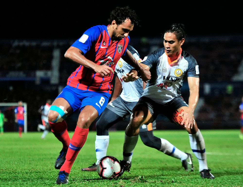 JDTu00e2u20acu2122s Diogo Luis Santo fights for the ball with PKNP FCu00e2u20acu2122s Amani Manual Aguinaldo during their Super League 2019 match in Johor Baru March 10, 2019. u00e2u20acu201d Bernama pic
