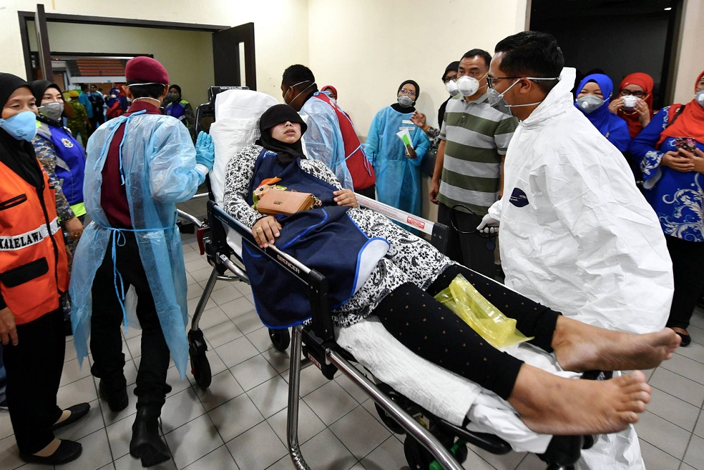 A woman is assisted into the Pasir Gudang Municipal Council Stadium medic base for treatment March 16, 2019. u00e2u20acu201d Bernama pic