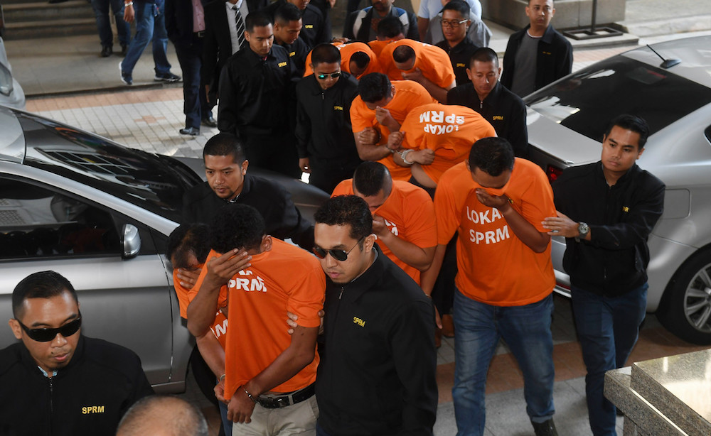 14 individuals accused of being part of a massage parlour protection racket are brought to the Putrajaya Magistrateu00e2u20acu2122s Court March 19, 2019. u00e2u20acu201d Bernama pic
