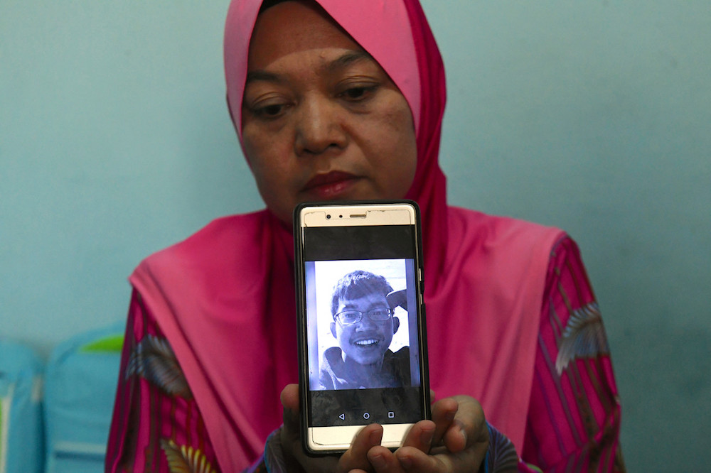 Zarina Shuib, 53, menunjukkan gambar Allahyarham Muhammad Haziq Mohd Tarmizi, 17, melalui telefon bimbitnya ketika ditemui media di kediamannya di Hutan Kampung, 21 Mac 2019. u00e2u20acu201d Foto Bernama