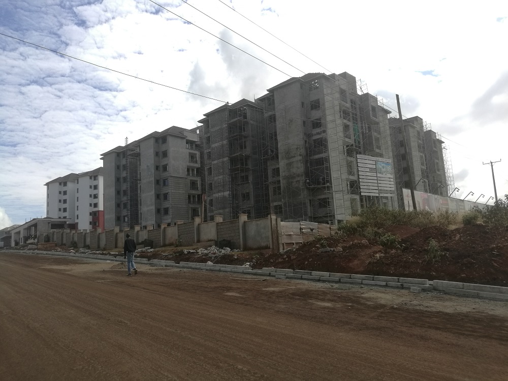 A man walks past a high-rise estate under construction at Tatu City in Kiambu County, Kenya. February 23, 2019. u00e2u20acu201d Thomson Reuters Foundation pic