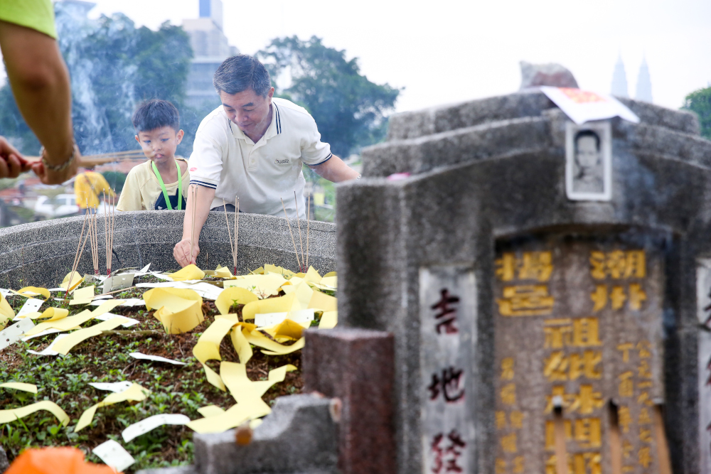 Relatives of the deceased making their offerings with joss sticks and other paraphernalia. u00e2u20acu201d Picture by Choo Choy May