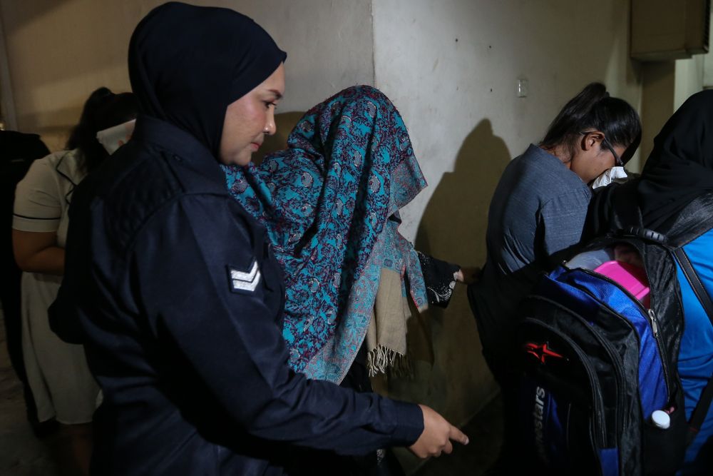 Samirah Muzaffar, the wife of Cradle Fund Sdn Bhd's late CEO Nazrin Hassan, is seen here being escorted by the police from the Petaling Jaya Magistrate's Court lock up March 4, 2019. u00e2u20acu201d Picture by Ahmad Zamzahuri