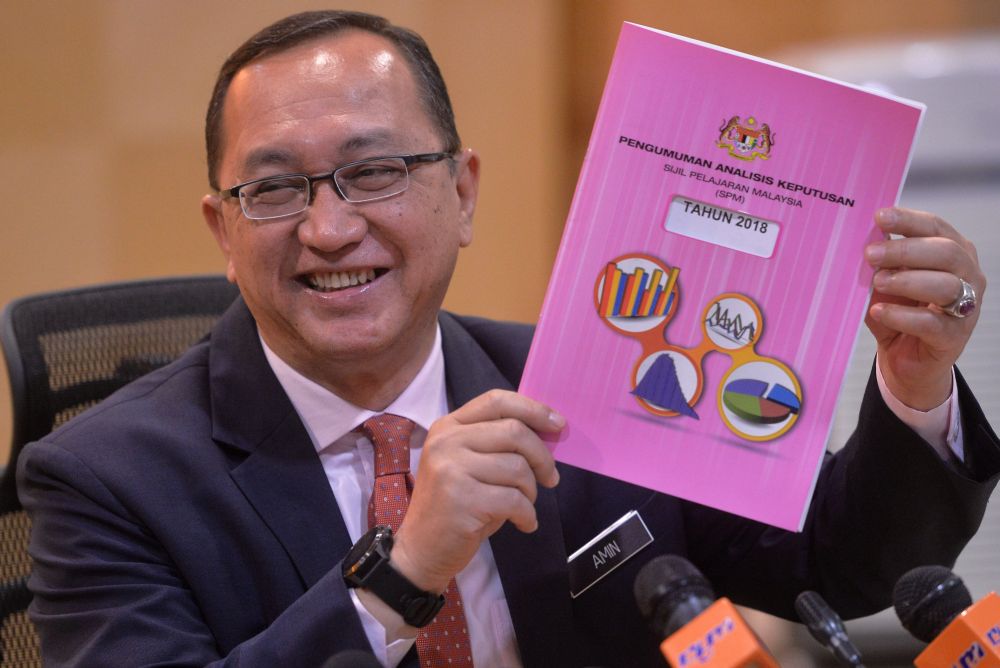 Datuk Amin Senin holds up a copy of the SPM result analysis report at the Ministry of Education in Putrajaya March 14, 2019. u00e2u20acu201d Picture by Shafwan Zaidon