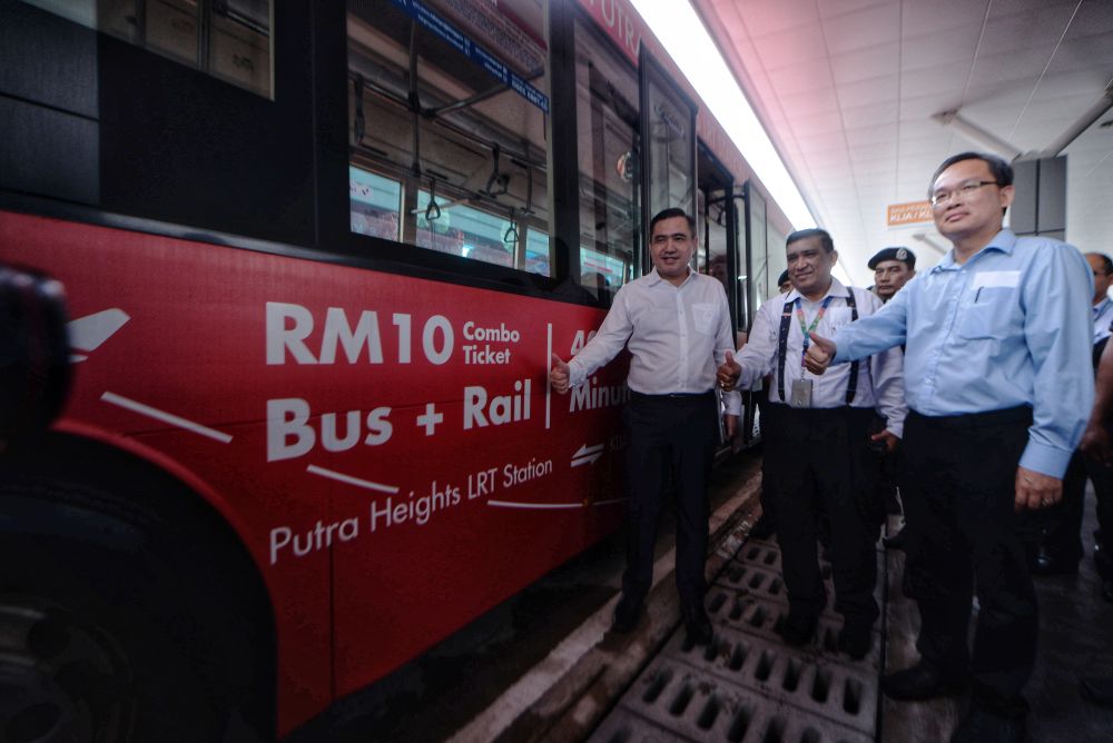 Transport Minister Anthony Loke (left) strikes a pose during the launch of the new KLIA, KLIA2 shuttle bus service at the Putra Heights LRT Station March 7, 2019. u00e2u20acu201d Picture by Shafwan Zaidon