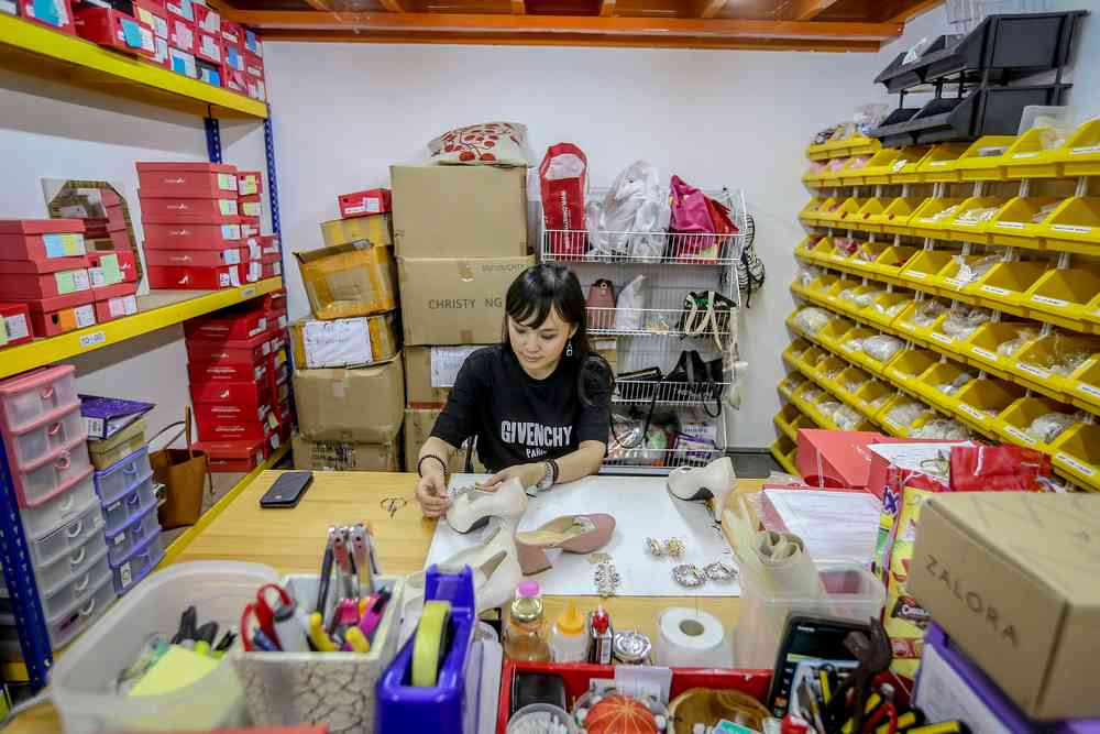 Ng puts the finishing touches on a custom pair of heels. — Picture by Firdaus Latif