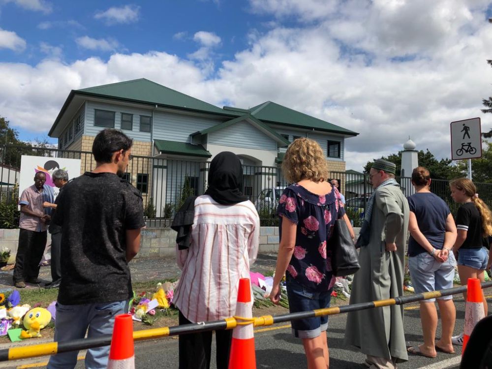 People gather with flowers and to pen messages in remembrance of the Christchurch shooting victims at a makeshift memorial in Hamilton, New Zealand on March 16, 2019. u00e2u20acu201d Picture courtesy of Shazly Khan.