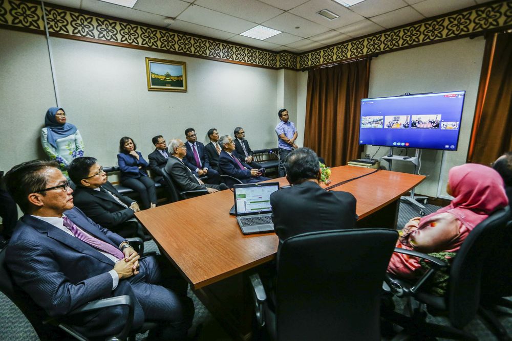 Datuk Liew Vui Keong (left) and Tan Sri Richard Malanjum (second from left) at a demonstration of the video conferencing service in the Kuala Lumpur court complex where lawyers for a case do not have to be physically in the same courtroom. March 12, 2019. — Picture by Hari Anggara