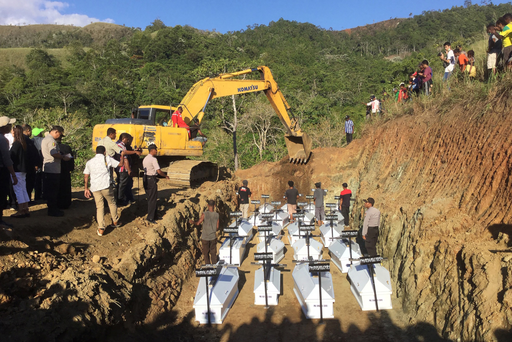 Caskets containing the remains of unidentified flash flood victims are buried in a mass grave in Sentani, Indonesia, March 27, 2019. u00e2u20acu201d AFP pic 