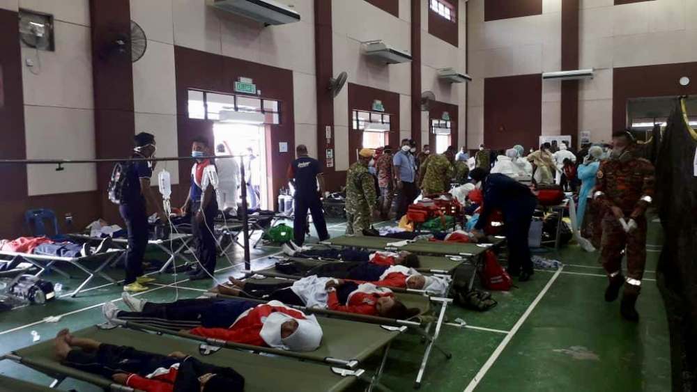 The scene where about 100 school students, believed to have breathing difficulties after inhaling fumes, being temporarily placed for health monitoring at the Taman Pasir Putih multipurpose hall in Pasir Gudang today. u00e2u20acu201d Picture by Ben Tan