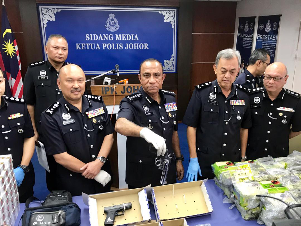 Johor police chief Datuk Mohd Khalil Kader Mohd holds up the seized .38 revolver at the Johor police contingent headquarters in Johor Baru March 24, 2019. u00e2u20acu201d Picture by Ben Tan